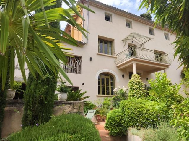 a large white house with a balcony on it at Bastide du château in Montfaucon