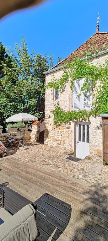 - un bâtiment en briques avec une table et un parasol dans l'établissement Tourellerenard, à Bussières-lès-Belmont