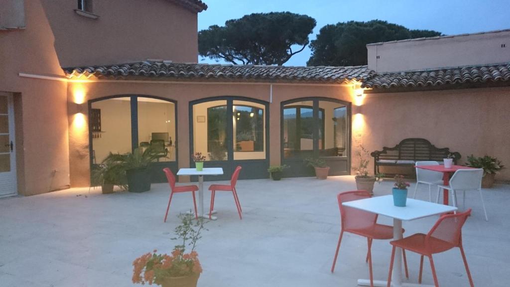 a patio with tables and chairs in front of a building at Hôtel les Bouis - Vue mer in Saint-Tropez