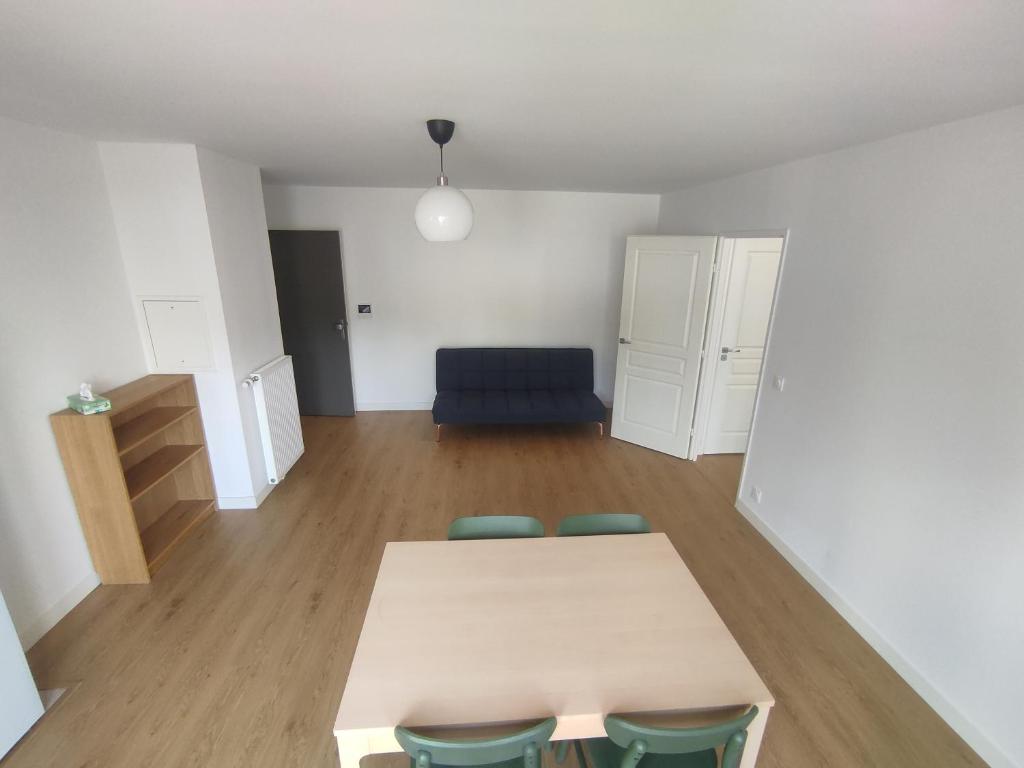 une pièce avec une table, des chaises et un canapé dans l'établissement Appartement proche des puces de Saint-Ouen, à Saint-Ouen
