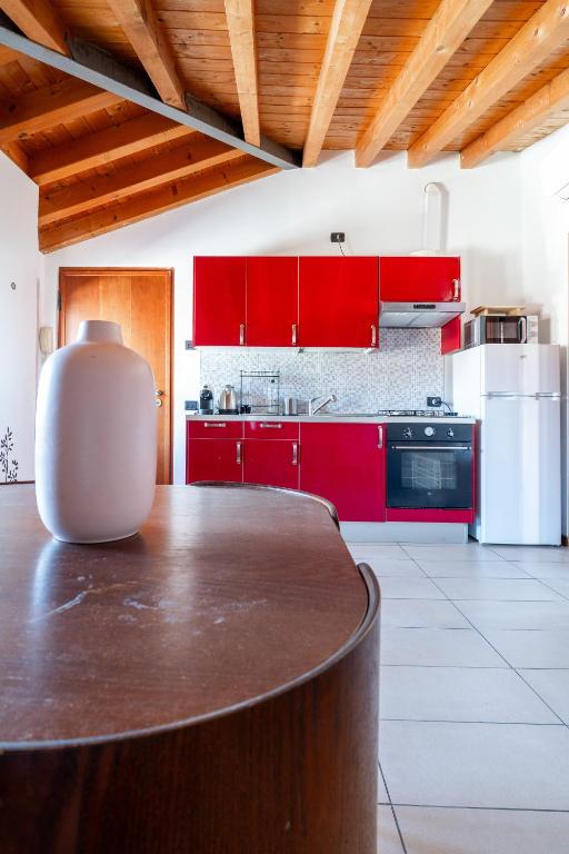 a kitchen with red cabinets and a wooden table at TAKE OFF Airport House in Orio al Serio