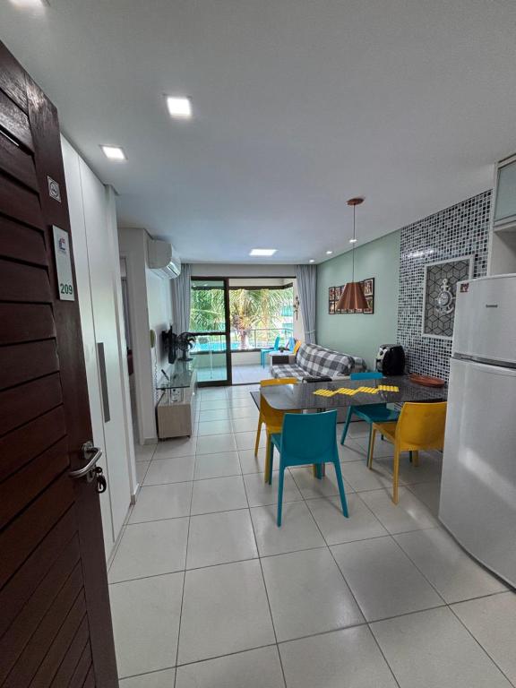 a kitchen and living room with a table and chairs at Carneiros Beach Resort Flat in Tamandaré