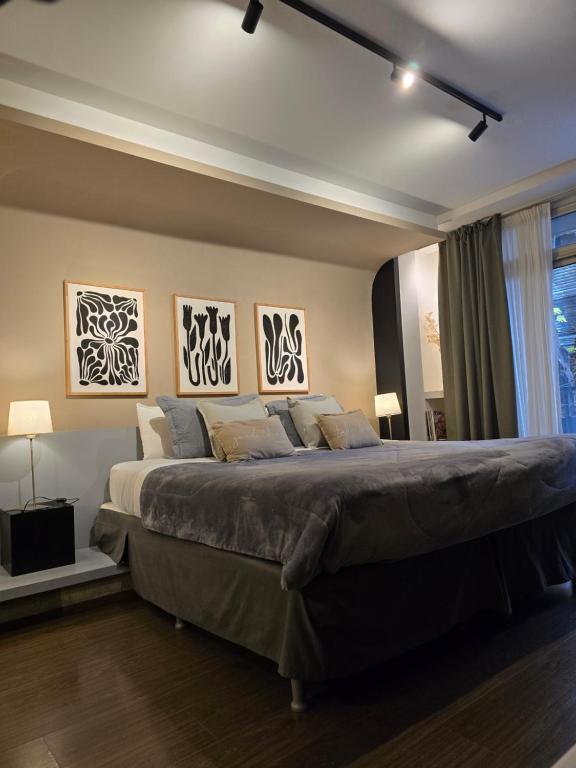 - une chambre avec un grand lit orné de 3 peintures murales dans l'établissement Studio FR Palermo Hollywood, à Buenos Aires