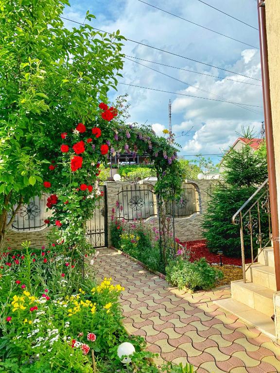 a garden with flowers and a gate with roses at HolidayHouse-Navodari in Năvodari