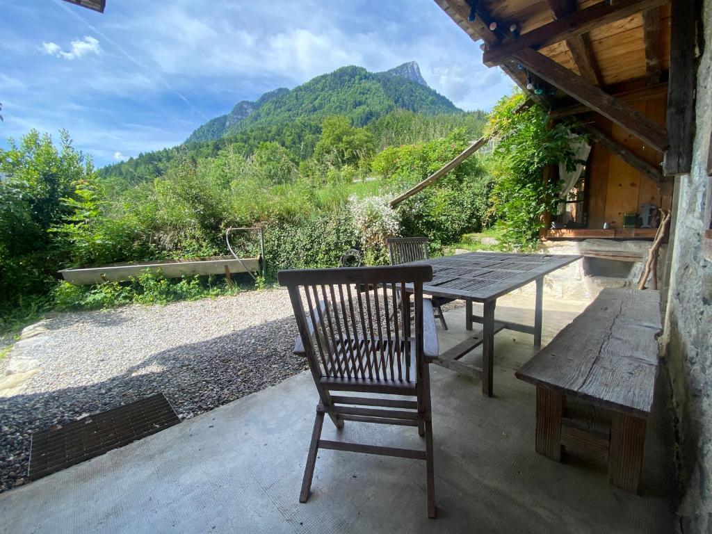 una mesa de madera y una silla de madera en el patio en Logement individuel 3 pièces dans chalet, en Glières-Val-de-Borne