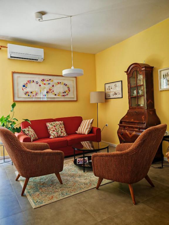 a living room with a red couch and a piano at Petra's House in Komaji