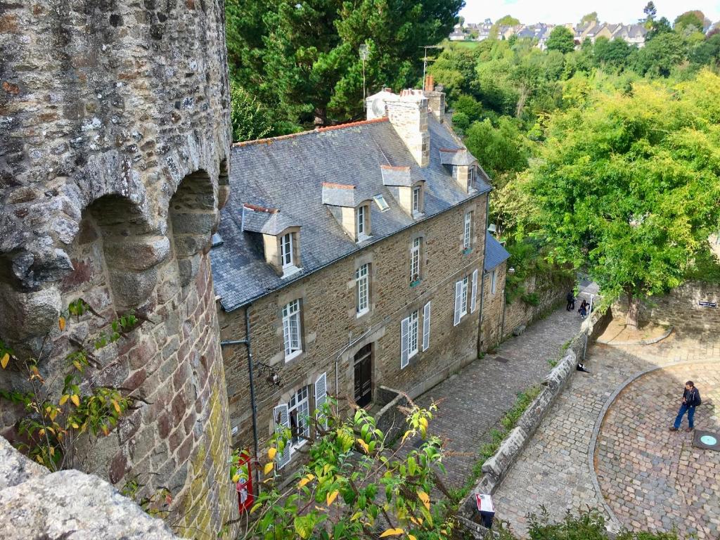 ein altes Steingebäude neben einem Schloss in der Unterkunft Le Cocon - La Vue des Remparts- Historical center in Dinan