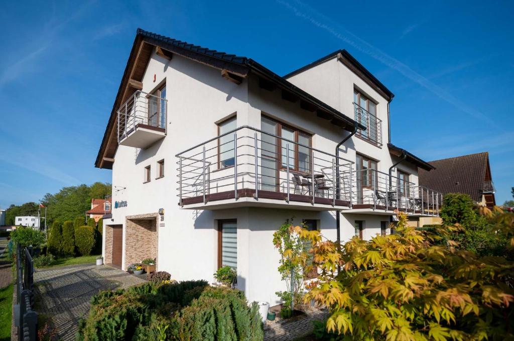 an exterior view of a white house with balconies at Turkus in Międzywodzie