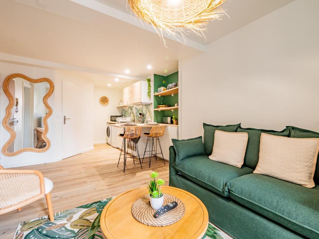un salon avec un canapé vert et une table dans l'établissement OIQIA • Advena • Floralis, à Annonay