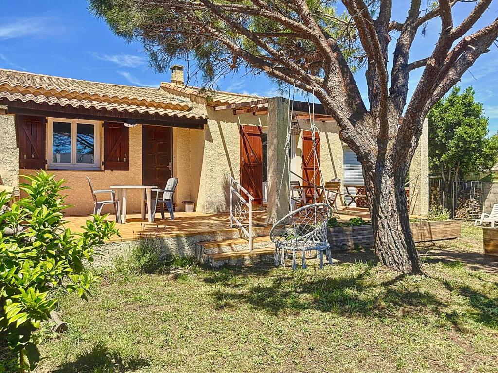 une maison avec une table et un arbre dans la cour dans l'établissement Maison avec jardin sur marseillan, à Marseillan