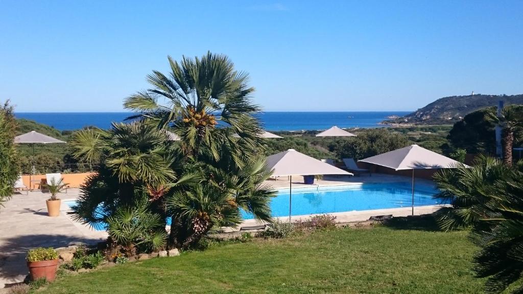 a resort with a swimming pool and the ocean at Hôtel les Bouis - Vue mer in Saint-Tropez