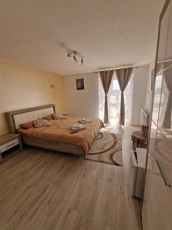 a bedroom with a bed and a large window at Casa dintre munti in Novaci