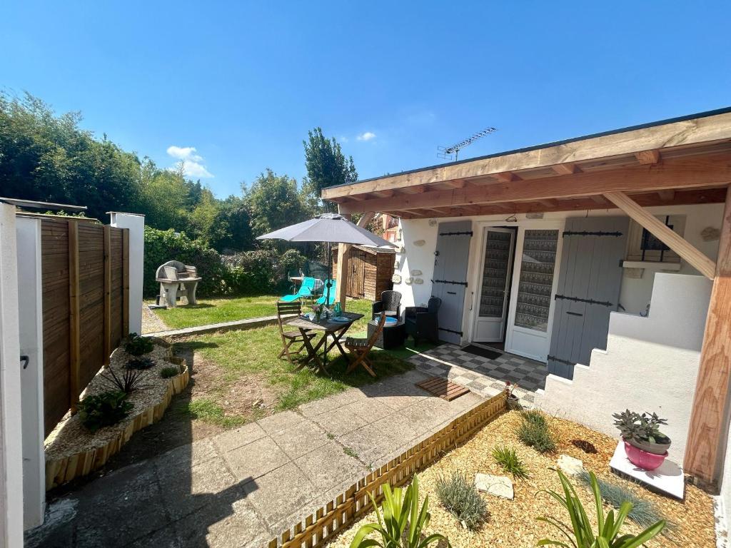 une maison avec un patio avec une table et un parasol dans l'établissement Maisonnette pour 2 personnes à 50m de la plage, à Saint-Palais-sur-Mer