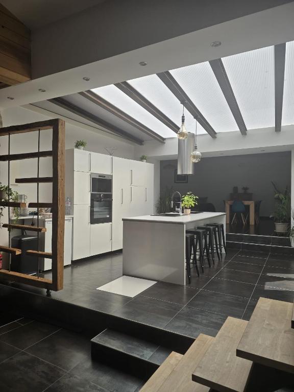 une cuisine avec des placards blancs et un îlot de cuisine dans l'établissement Charmant appartement 6 couchages, à Sommières