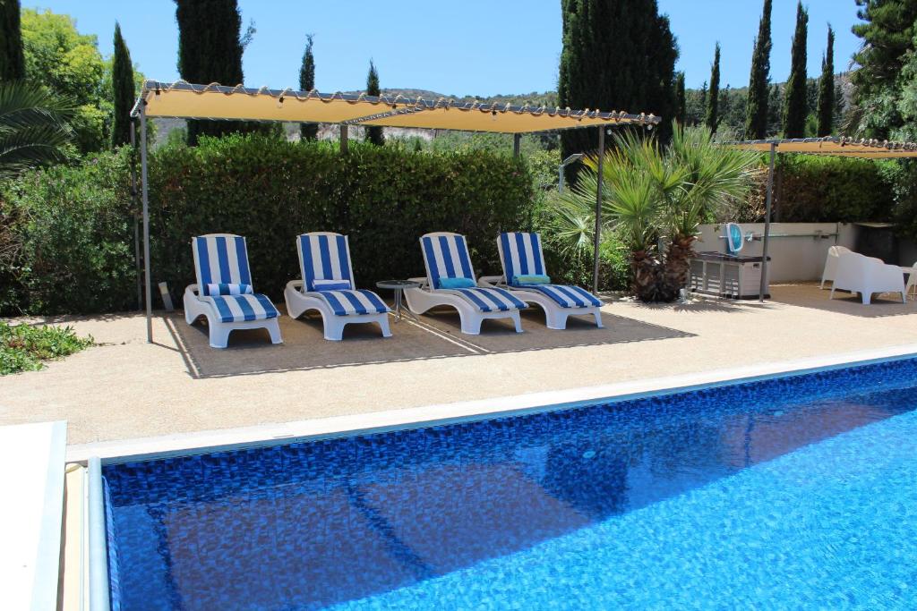 a group of blue and white chairs next to a swimming pool at St.George's Country Retreat in Limassol