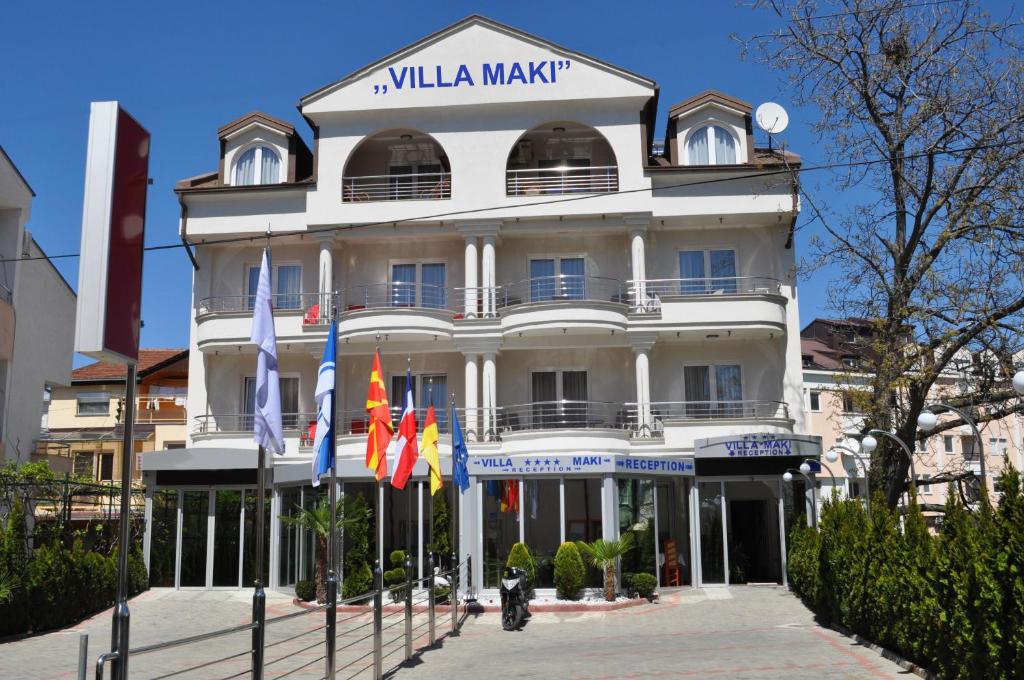 un edificio blanco con banderas delante en Villa Maki, en Ohrid