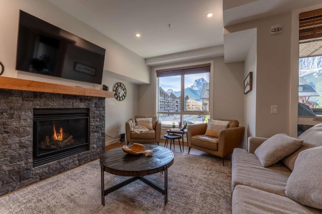 a living room with a couch and a fireplace at Modern Mountain Oasis Top floor 2 level 2bd in Canmore