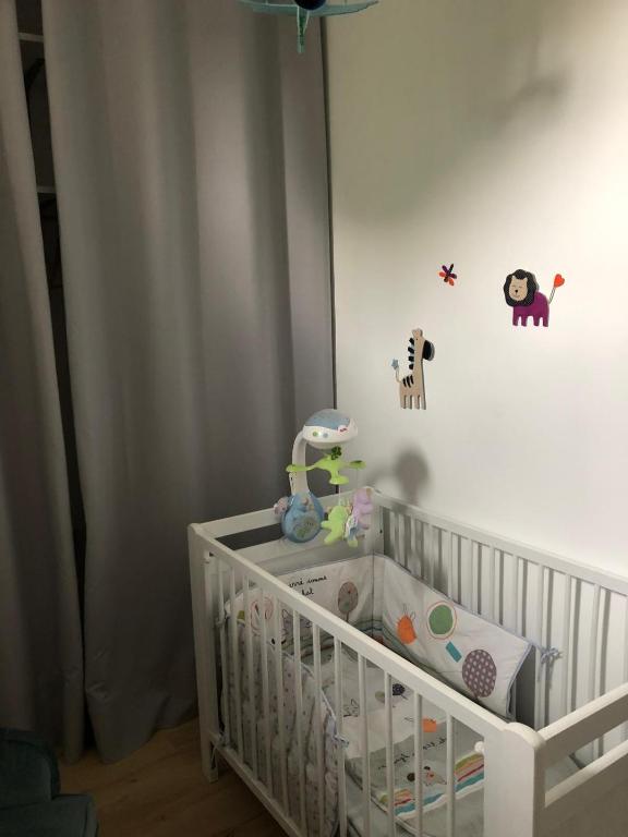 - un lit bébé blanc dans une chambre avec un lit bébé dans l'établissement Maison familiale à la campagne, à Cassagne