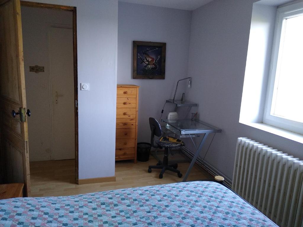 a bedroom with a bed and a desk with a computer at Chambre à louer hors weekend chez Fiona in Laval