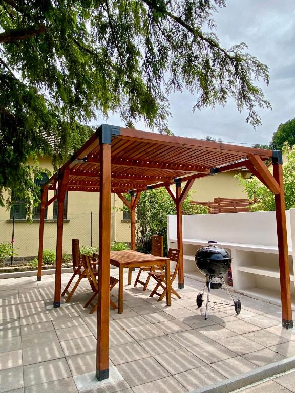 - un pavillon en bois avec une table et un grill dans l'établissement La Villa Hortensia, à Jungholtz