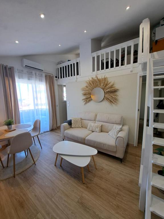 un salon avec un canapé et une table dans l'établissement Appartement proche bord de mer, au Barcarès