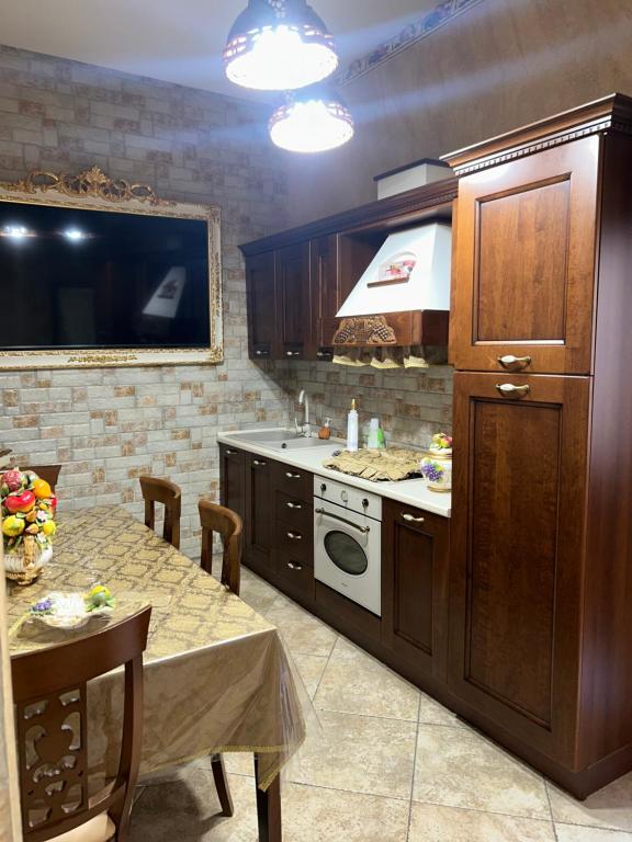 a kitchen with a table and a stove top oven at Barocco House in Catania