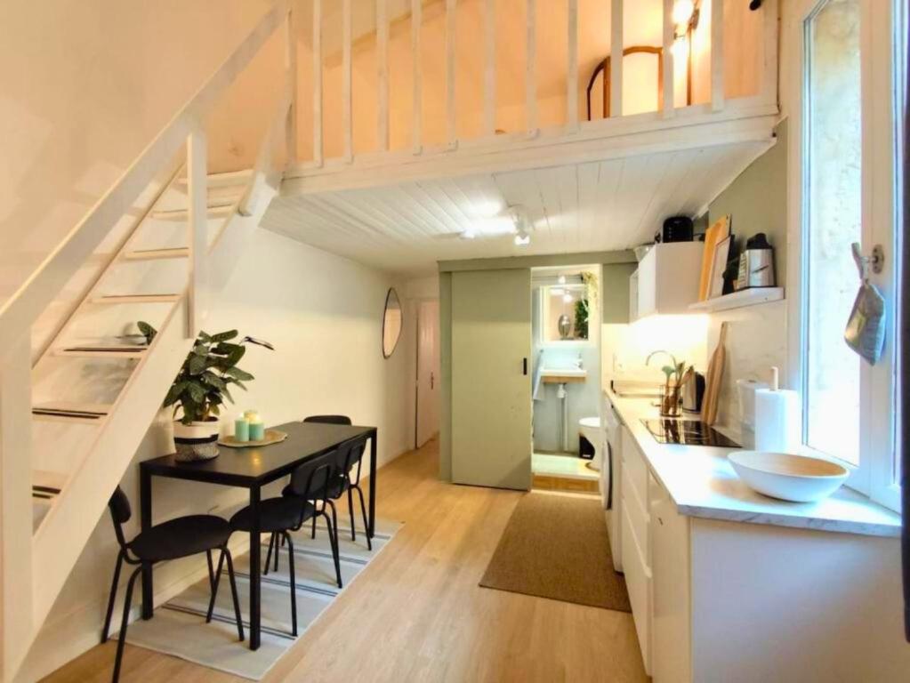 une petite cuisine et salle à manger avec une table et un escalier dans l'établissement Appartement de charme 2ch centre historique, WIFI, à Montpellier