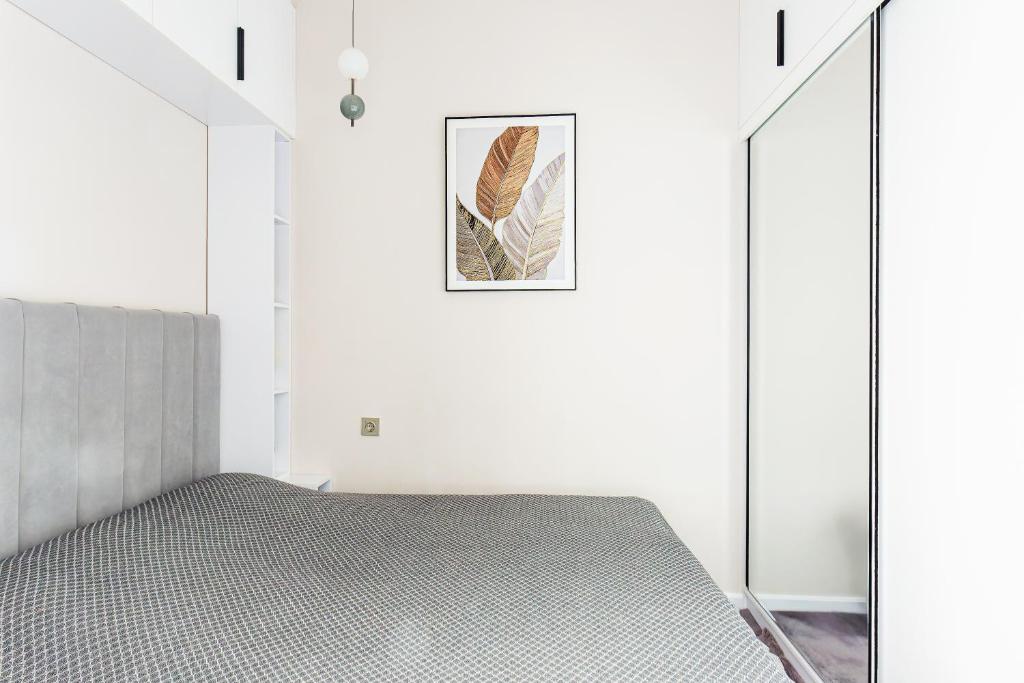 un lit dans une chambre aux murs blancs dans l'établissement Silk Road Skyline Tashkent City, à Tachkent