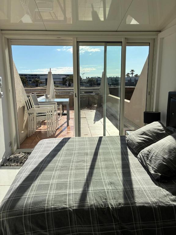 - une chambre avec un lit et une vue sur une terrasse dans l'établissement Naturiste Cap d'Agde Héliopolis F 4, au Cap d'Agde