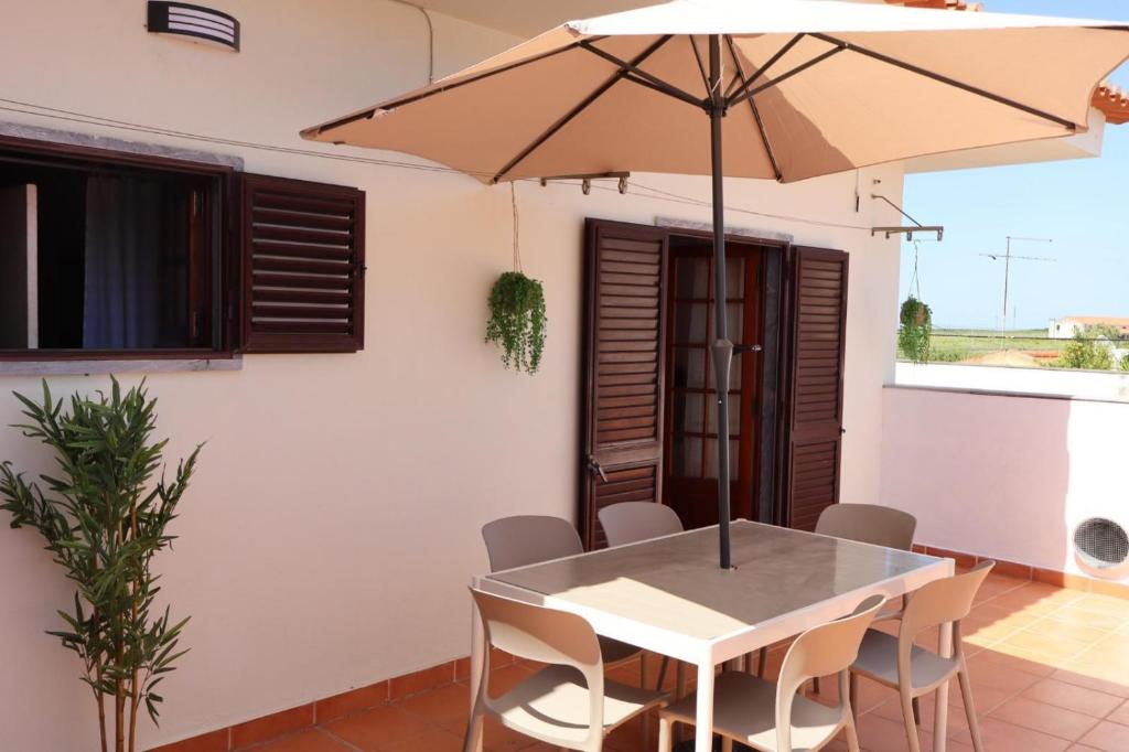 a table and chairs with an umbrella on a patio at Terras da Planície in Ferreira do Alentejo