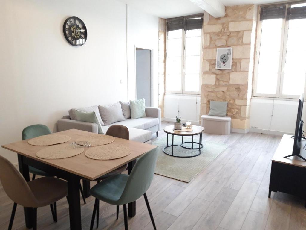 un salon avec une table et un canapé dans l'établissement Appartement de charme proche citadelle, à Blaye