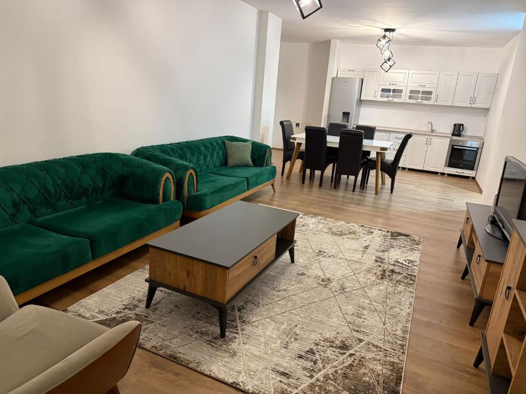 a living room with a green couch and a table at Riga's Apartment in Prizren