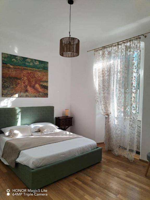 a bedroom with a green bed and a window at Kalìda Space - Camera matrimoniale in La Spezia