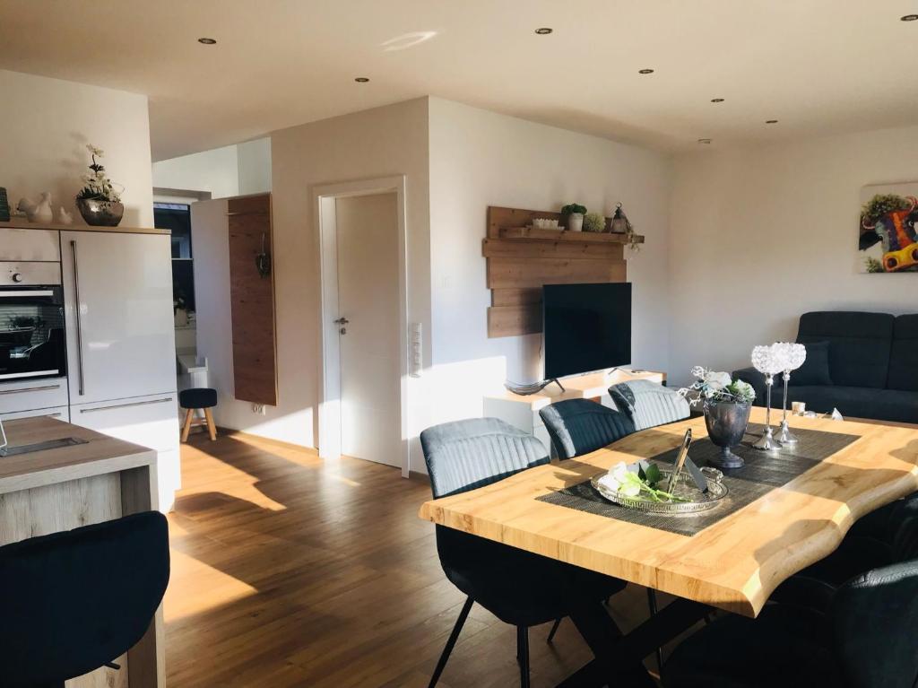 a kitchen and living room with a wooden table at Luxus Ferienhaus Geest und Moor in Großheide