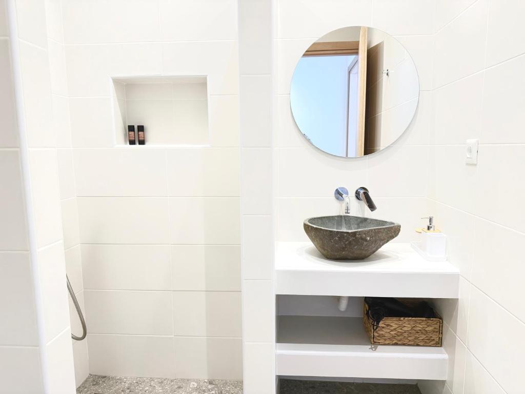 a white bathroom with a sink and a mirror at Sakellis Home 2- Steps to Beach & Town in Kardamaina