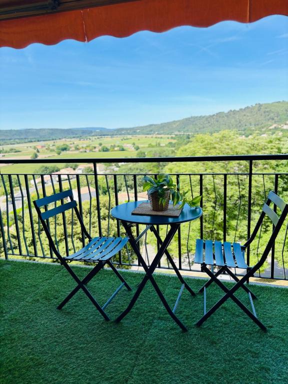 une table et deux chaises sur un balcon avec vue dans l'établissement Studio à Gréoux les bains - Les Fontaines, à Gréoux-les-Bains