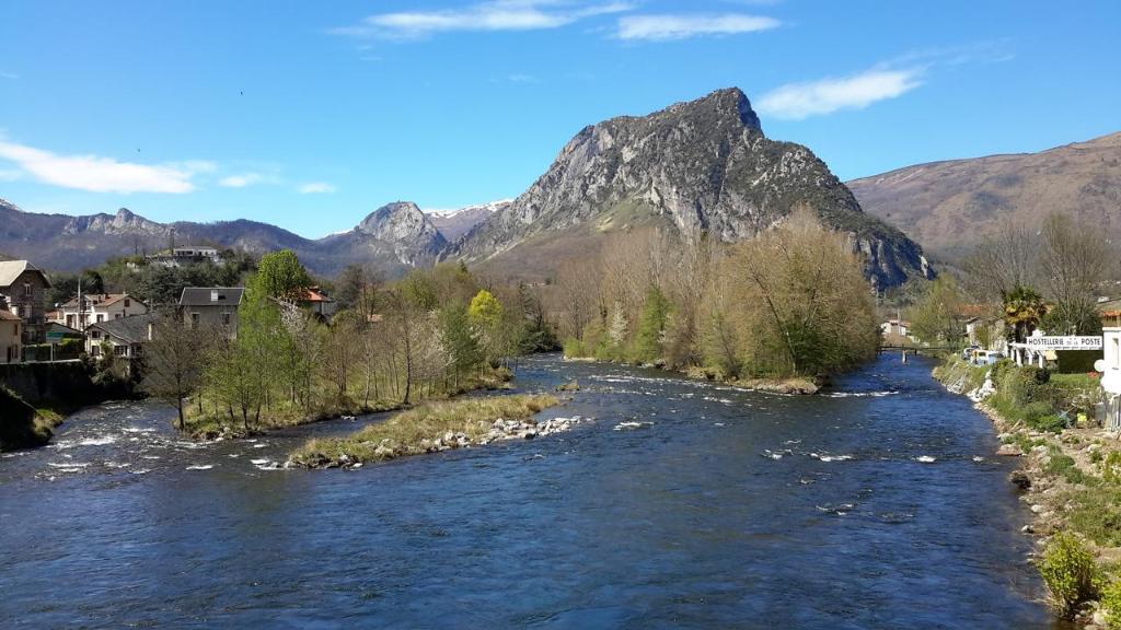 a river in a town with a mountain in the background at Chambres d'hôtes Belle Occitane in Tarascon-sur-Ariège