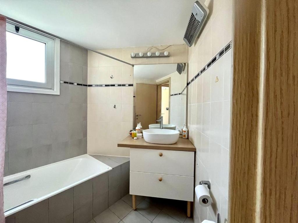 a bathroom with a tub and a sink and a bath tub at Cozy Stay Nicosia in Nicosia