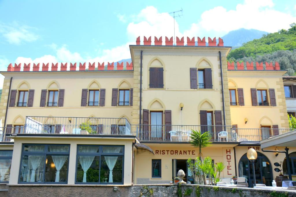 un grande edificio giallo con un ristorante in cima di Hotel e Ristorante Cassone a Malcesine