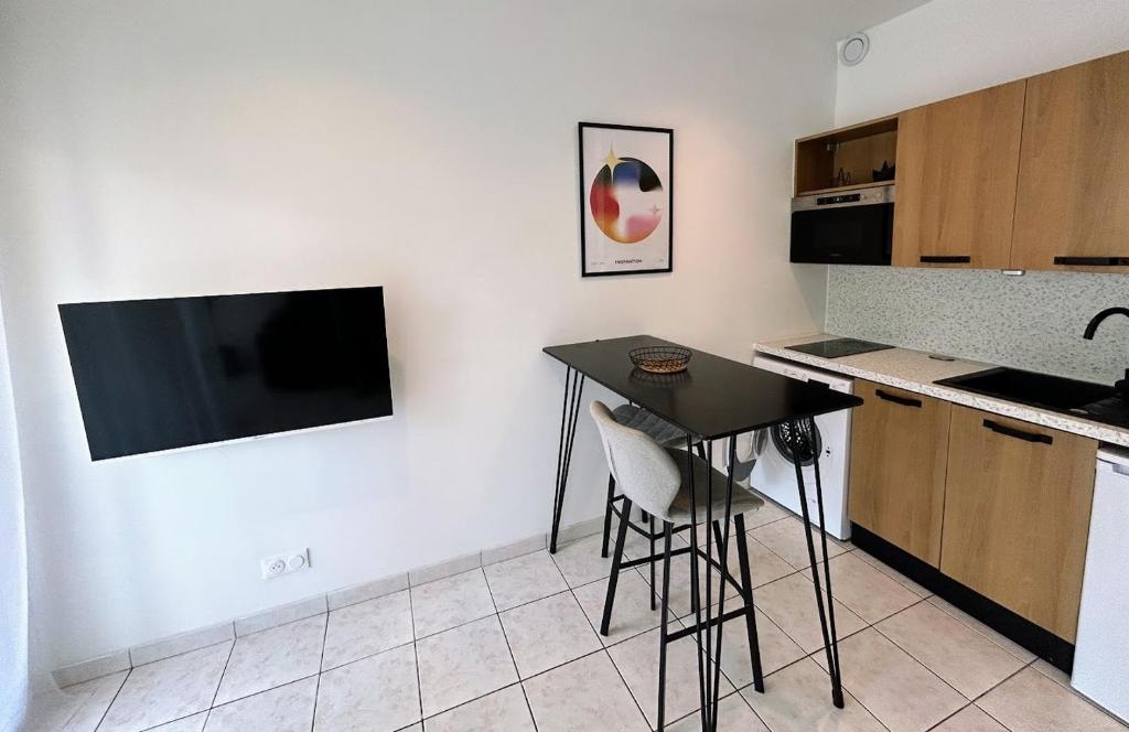 une cuisine avec une table noire et un comptoir dans l'établissement Joli appartement au bord de mer, à Nice