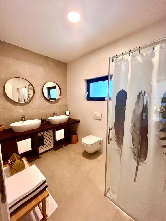 łazienka z 2 umywalkami, prysznicem i toaletą w obiekcie Casa Bosca with heated pool w mieście Sveti Petar u Šumi
