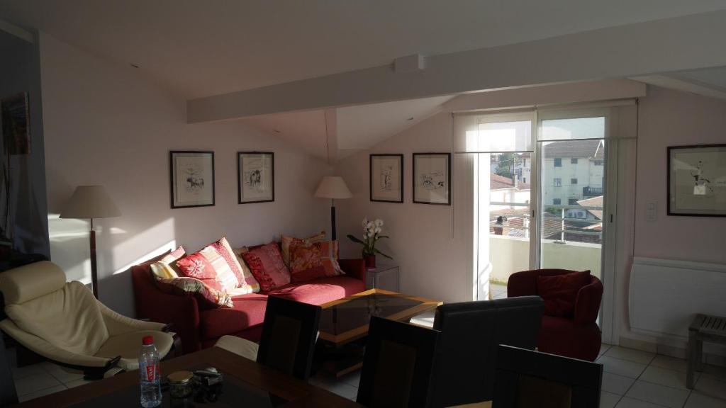 un salon avec un canapé, des chaises et une fenêtre dans l'établissement Myfamily, à Capbreton