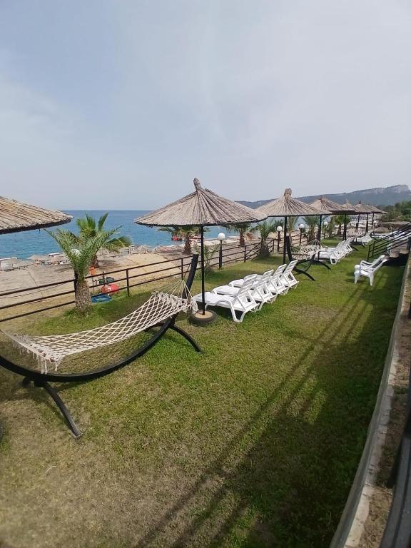 a group of hammocks and umbrellas at a beach at THE SANDHİLl OTEL RESTAURANT in Kemer