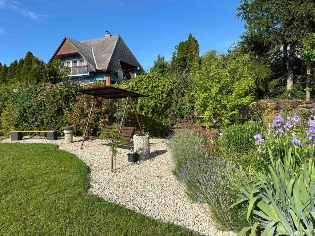 un jardín con una casa en el fondo en Szőlőskert Apartman, en Cserszegtomaj