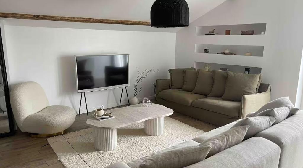 un salon avec un canapé et une télévision dans l'établissement La Casa Familia - Plage à 10 min - Terrasse ensoleillée - 70m2, à La Teste-de-Buch