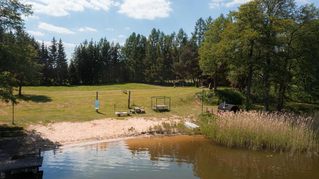 a park with a playground next to a pond at Domek Nad Jeziorem Mazury in Miłomłyn