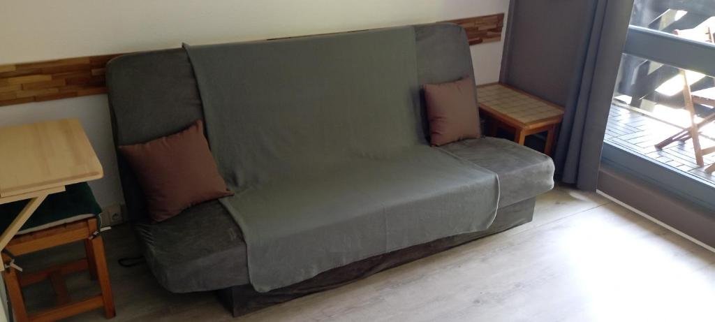 - un canapé vert avec des oreillers dans le salon dans l'établissement Appartement au Cœur du Col de Rousset, à Saint-Agnan-en-Vercors