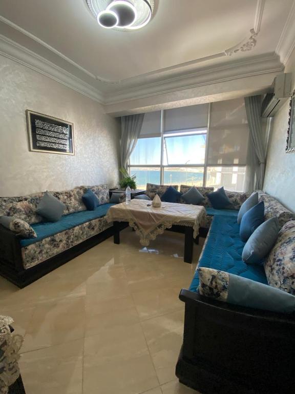 a living room with a blue couch and a table at luxury sea view apartment in Tangier