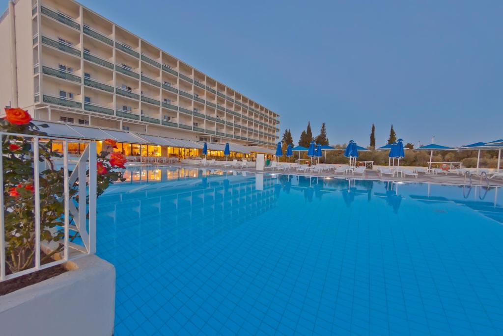 a large swimming pool in front of a hotel at Palmariva Beach Hotel in Eretria