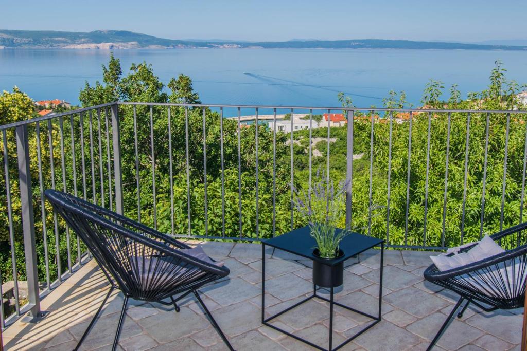 patio z 2 krzesłami i stołem z widokiem na wodę w obiekcie Apartment Vincent with beautiful sea view terrace w mieście Klenovica